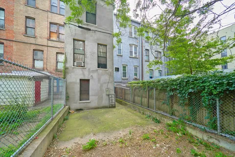front view of a brick house with a yard