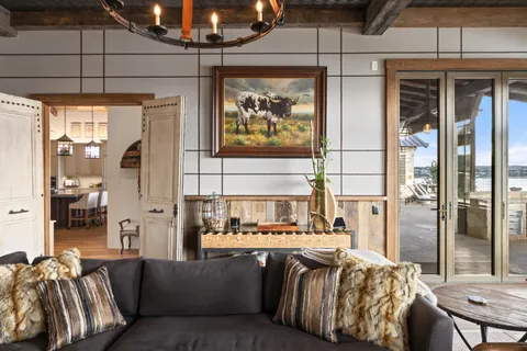 a living room with furniture a flat screen tv and a floor to ceiling window