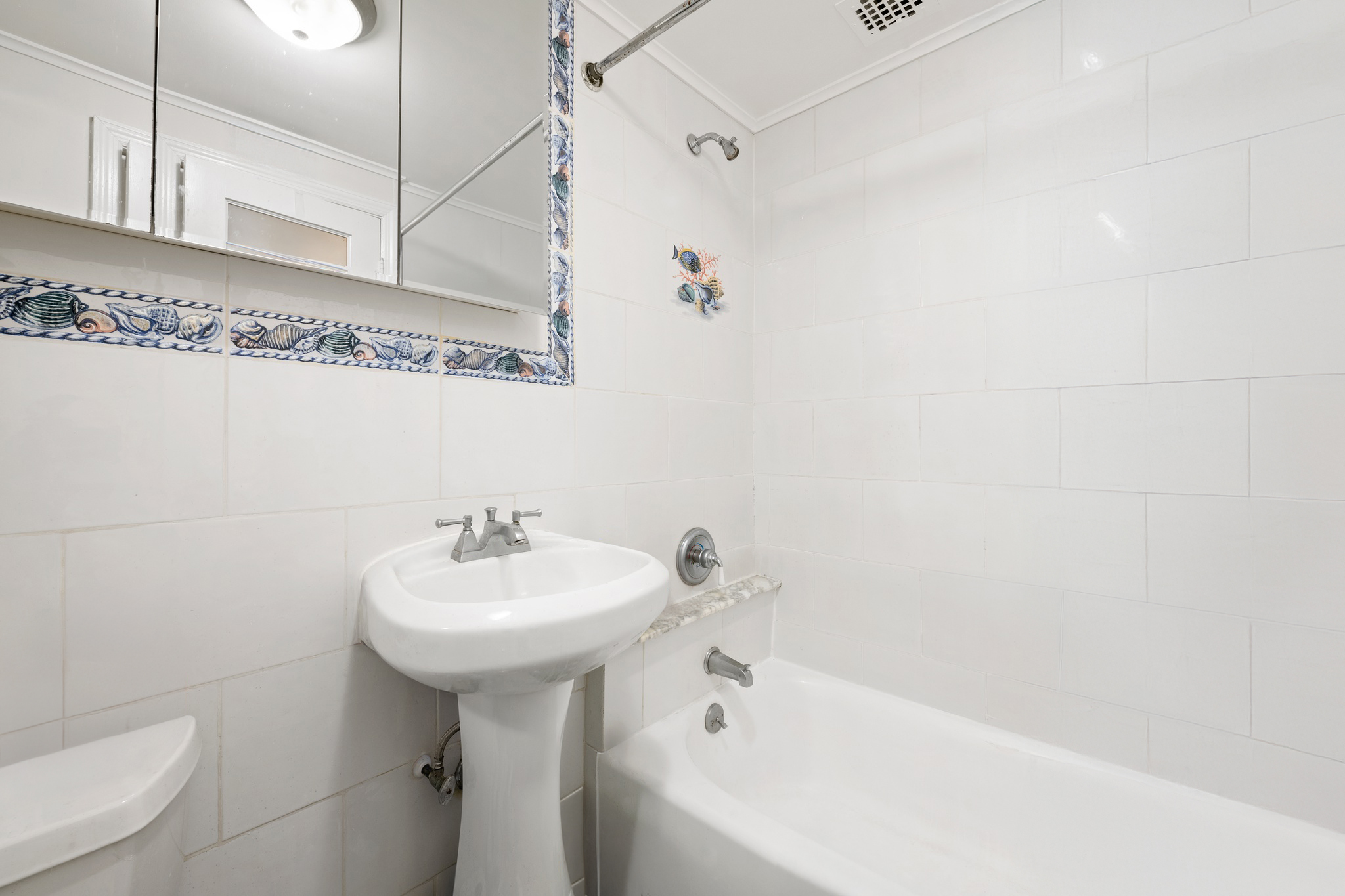 305 West 55th Street, Unit 2B Manhattan, NY 10019 - Photo 7 of 9 a bathroom with a sink a mirror and a bathtub