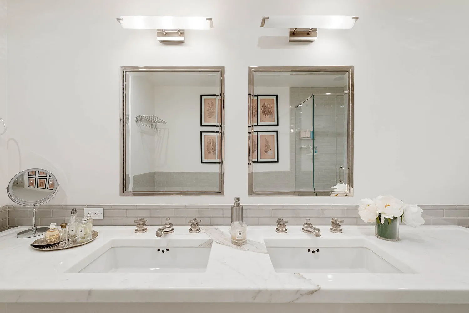 a bathroom with double vanity sinks and a mirror