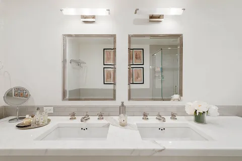 a bathroom with double vanity sinks and a mirror