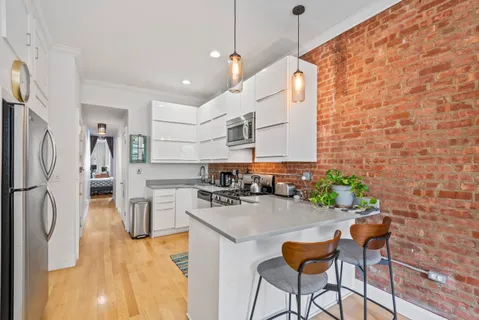 a kitchen with stainless steel appliances kitchen island granite countertop a sink and a refrigerator