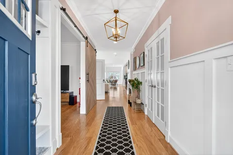 a hallway with a dining table and a chandelier