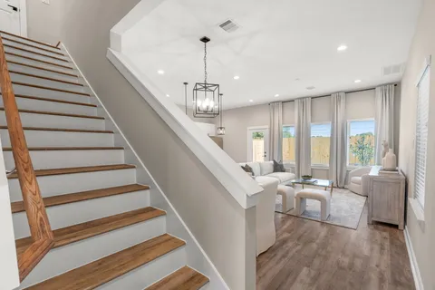 a living room with furniture and stairs