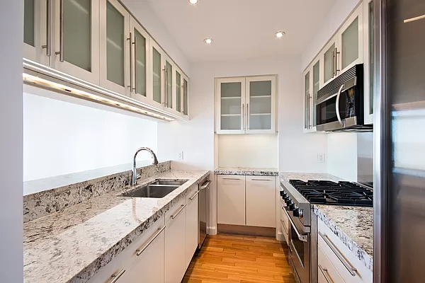 100 Morton Street, Unit 14CW Manhattan, NY 10014 - Photo 3 of 8 a kitchen with stainless steel appliances granite countertop a sink stove and microwave