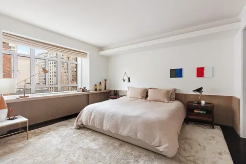 a bedroom with a bed and a large window