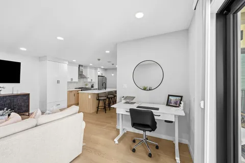 a living room with furniture a flat screen tv and a mirror