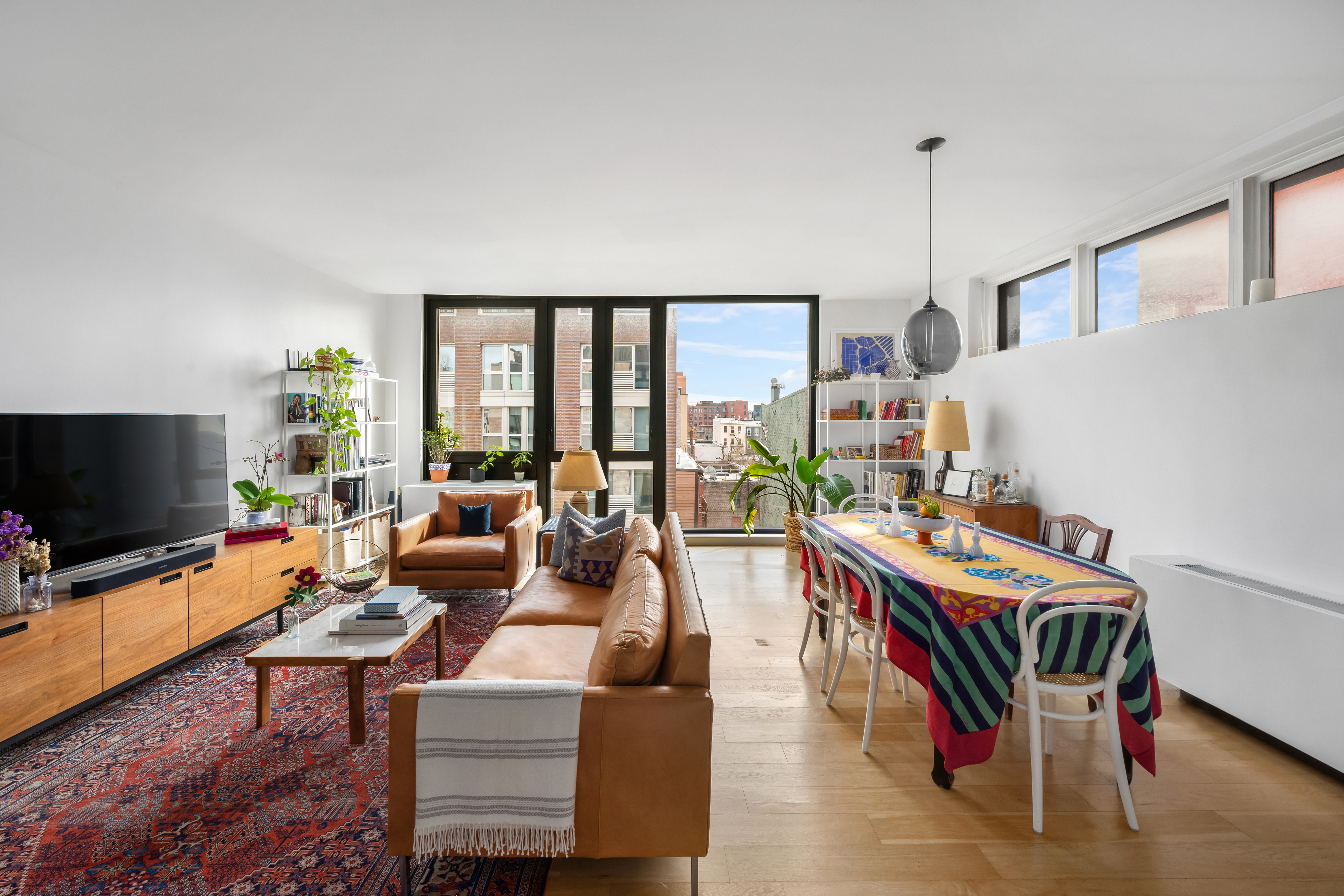70 Berry Street, Unit 5G Brooklyn, NY 11249 - Photo 3 of 10 a living room with furniture a flat screen tv and floor to ceiling window