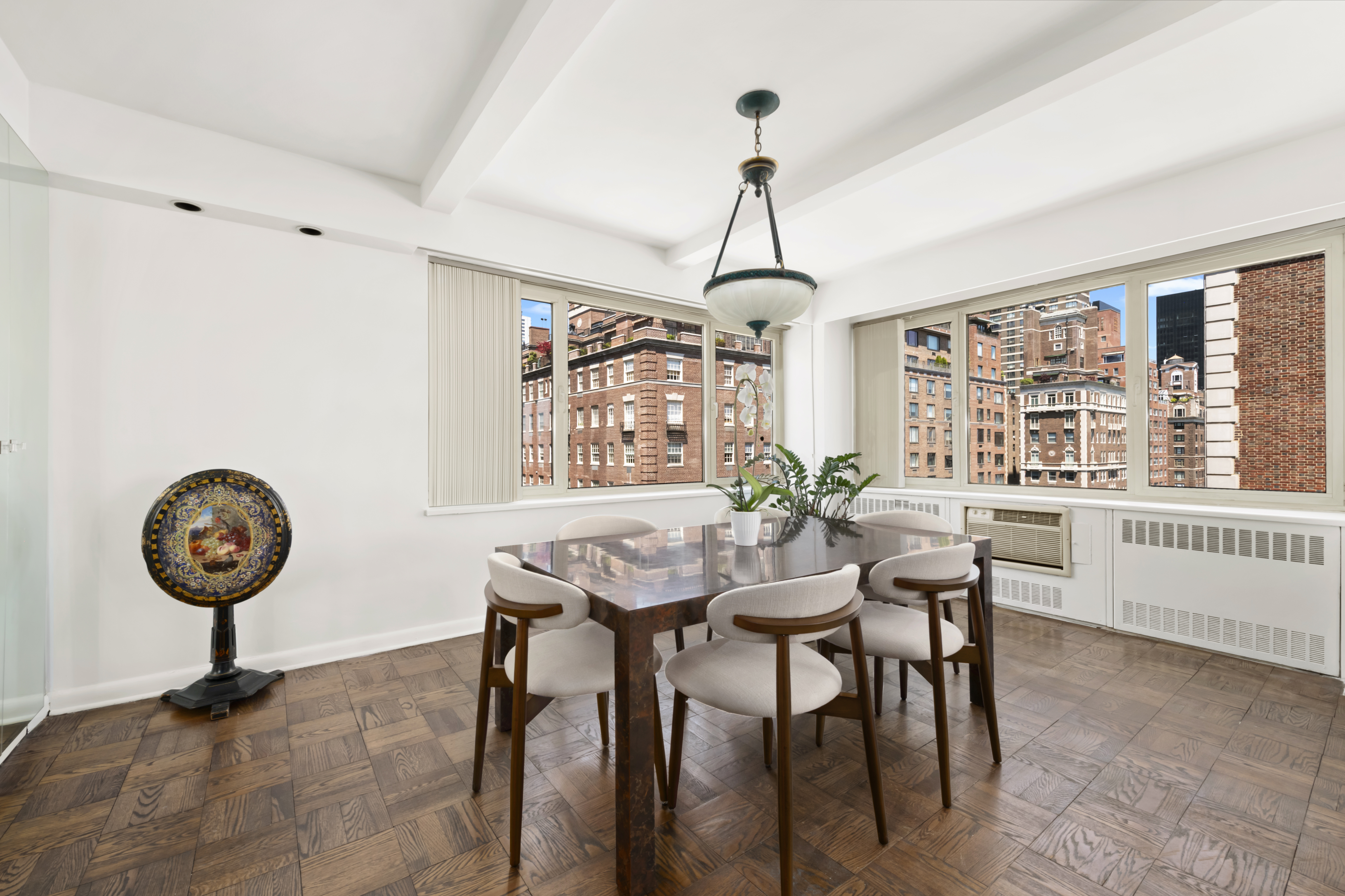 25 Sutton Place South, Unit 16B Manhattan, NY 10022 - Photo 5 of 16 a view of a dining room with furniture window and wooden floor