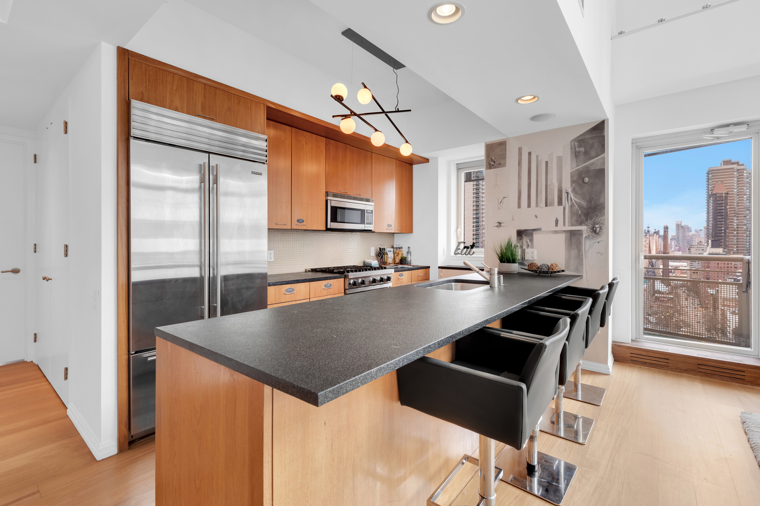 205 East 59th Street, Unit 19A Manhattan, NY 10022 - Photo 5 of 14 a kitchen with granite countertop a stove a sink a dining table and chairs