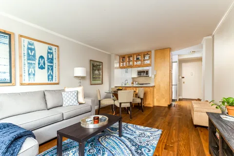 a living room with furniture and a wooden floor