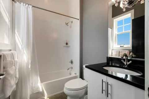 a bathroom with a granite countertop sink toilet and shower