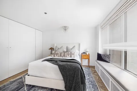 a bedroom with a bed and a large window