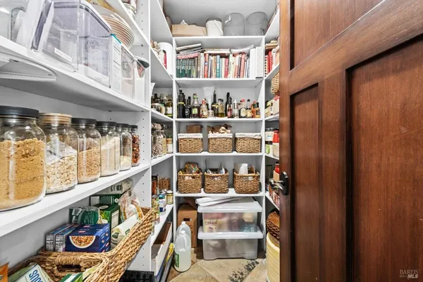 a view of a patio with table and chairs under an umbrella with a small yard