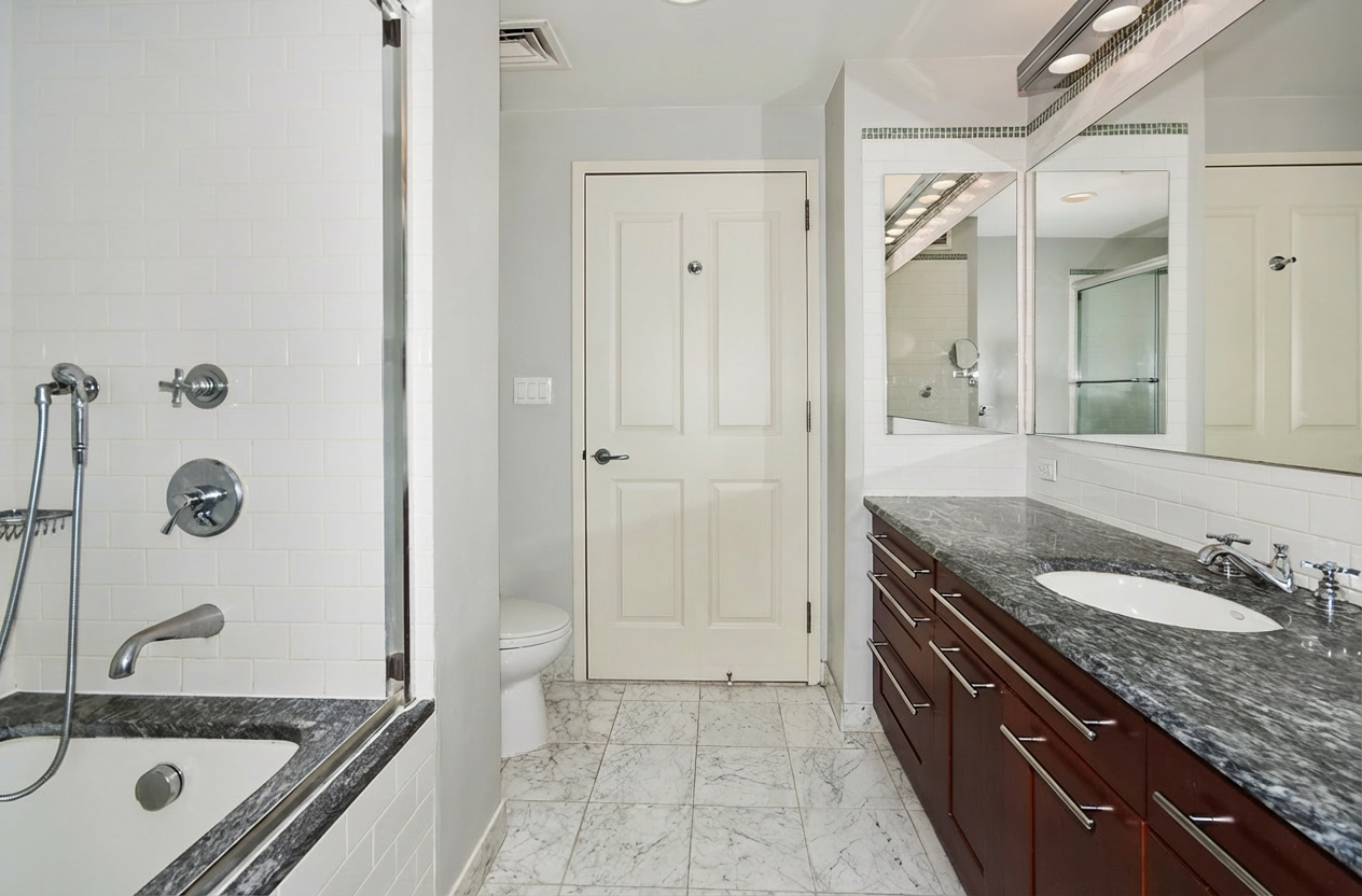272 West 107th Street, Unit 15B Manhattan, NY 10025 - Photo 7 of 10 a bathroom with a granite countertop sink mirror and a bathtub