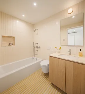 a bathroom with a toilet a sink a tub and a mirror