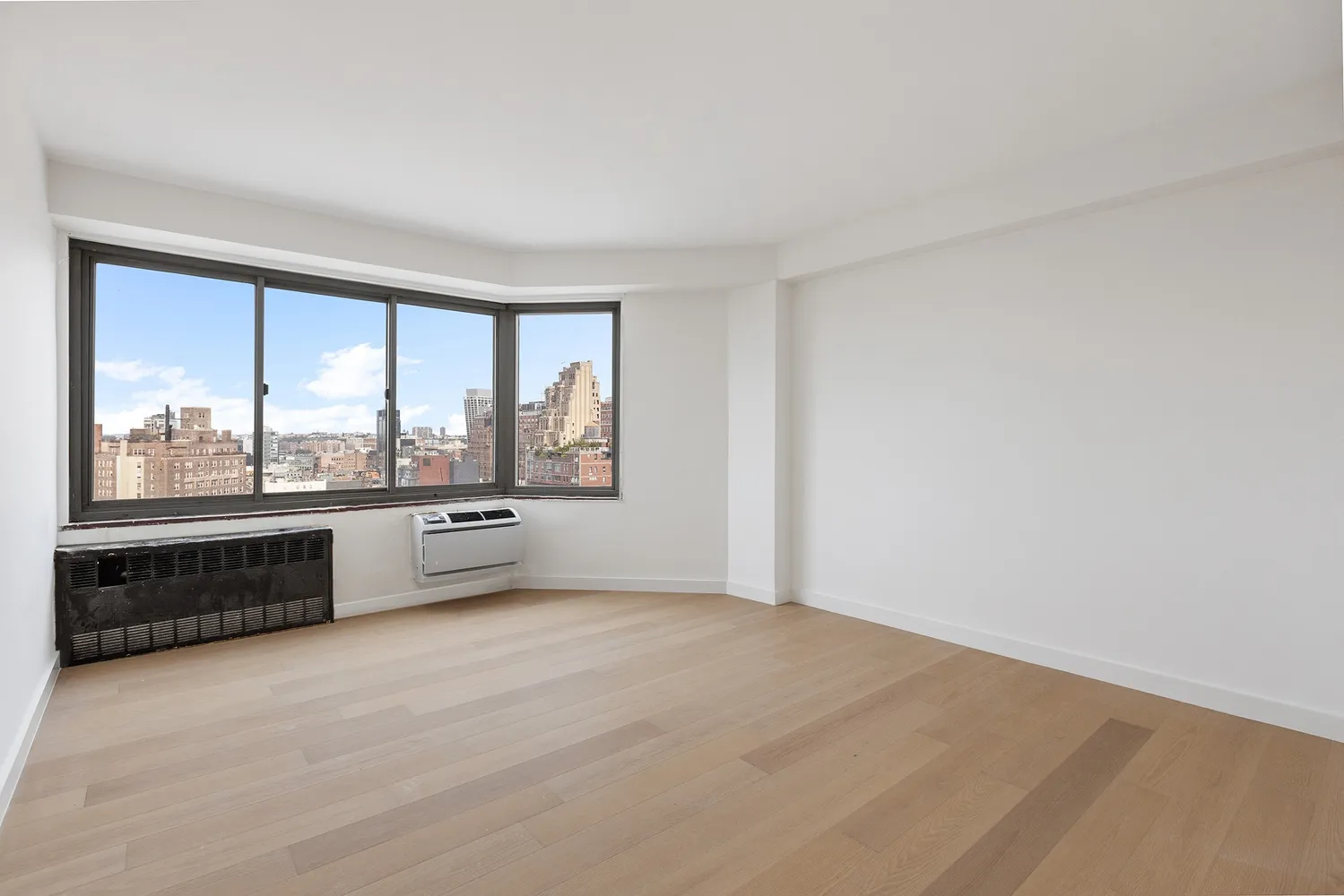 an empty room with a large window and view of outdoor space