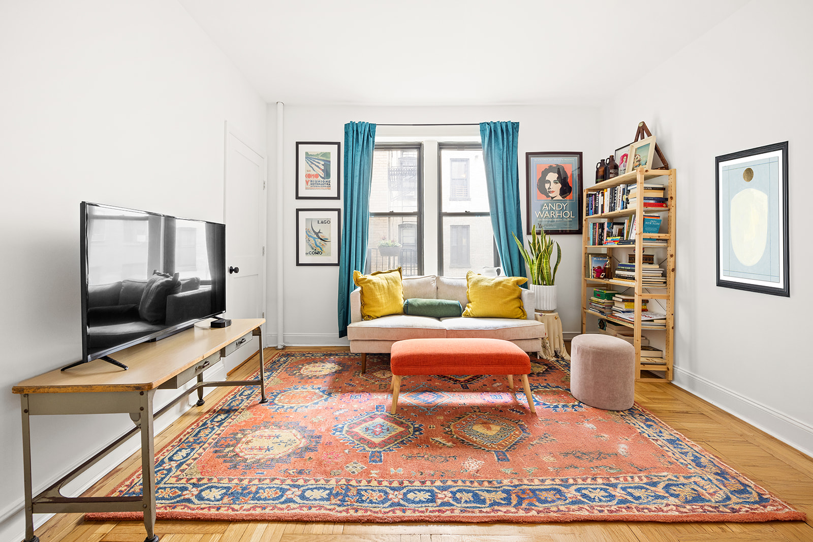 a living room with furniture a flat screen tv and a table