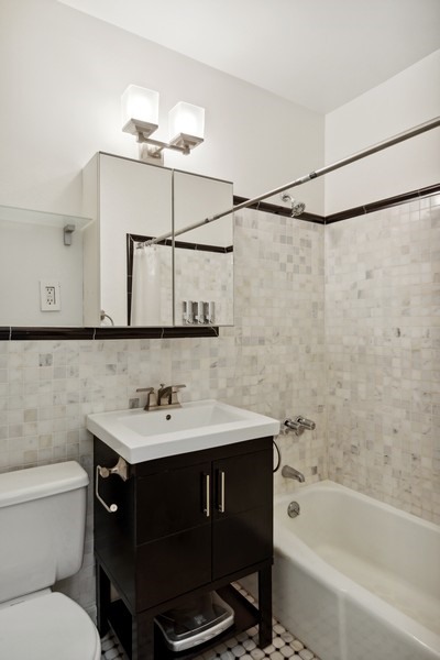 689 Fort Washington Avenue, Unit 4B Manhattan, NY 10040 - Photo 7 of 13 a bathroom with a sink vanity toilet and shower