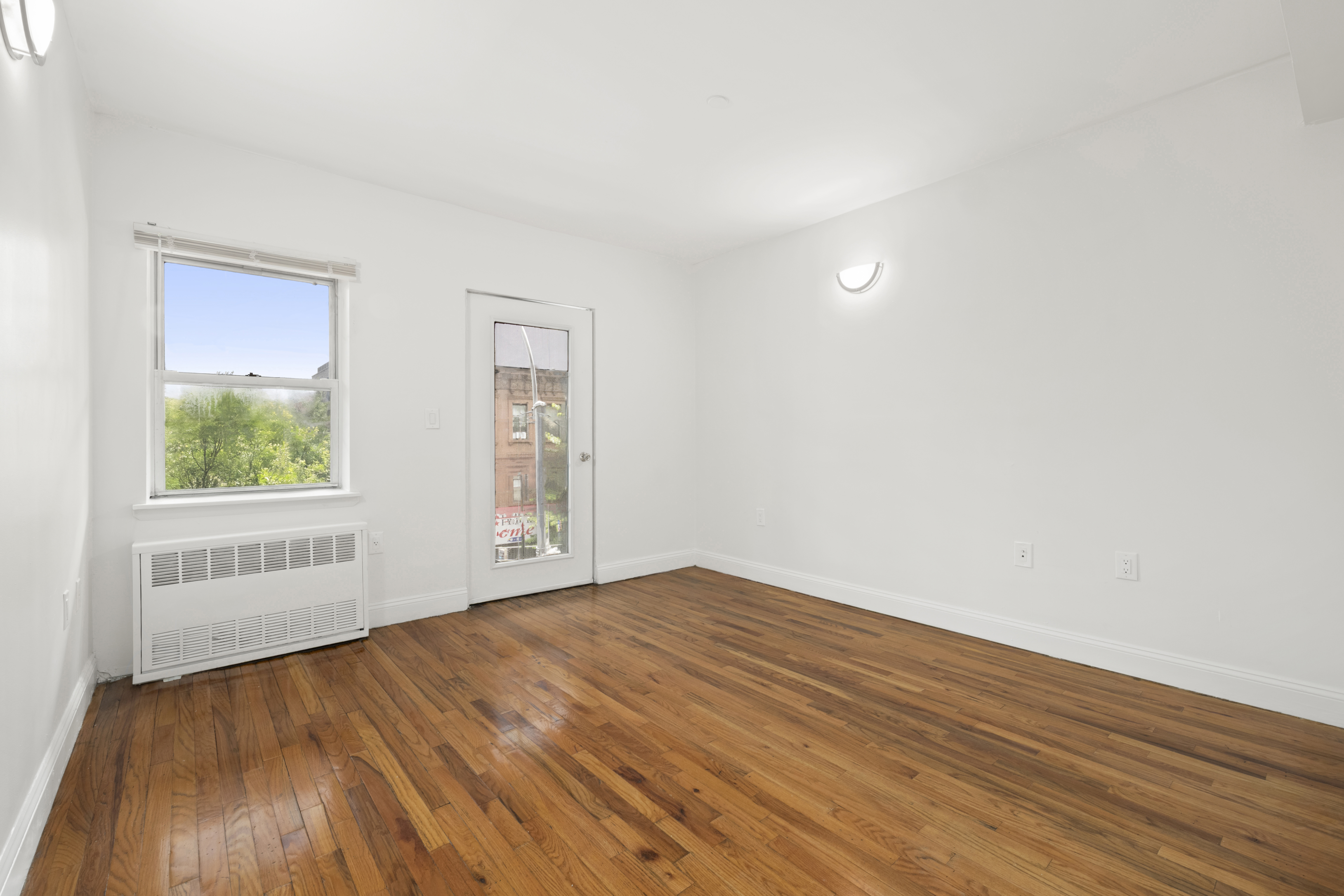 1240 Bedford Avenue, Unit 3H Brooklyn, NY 11216 - Photo 2 of 12 an empty room with wooden floor and windows
