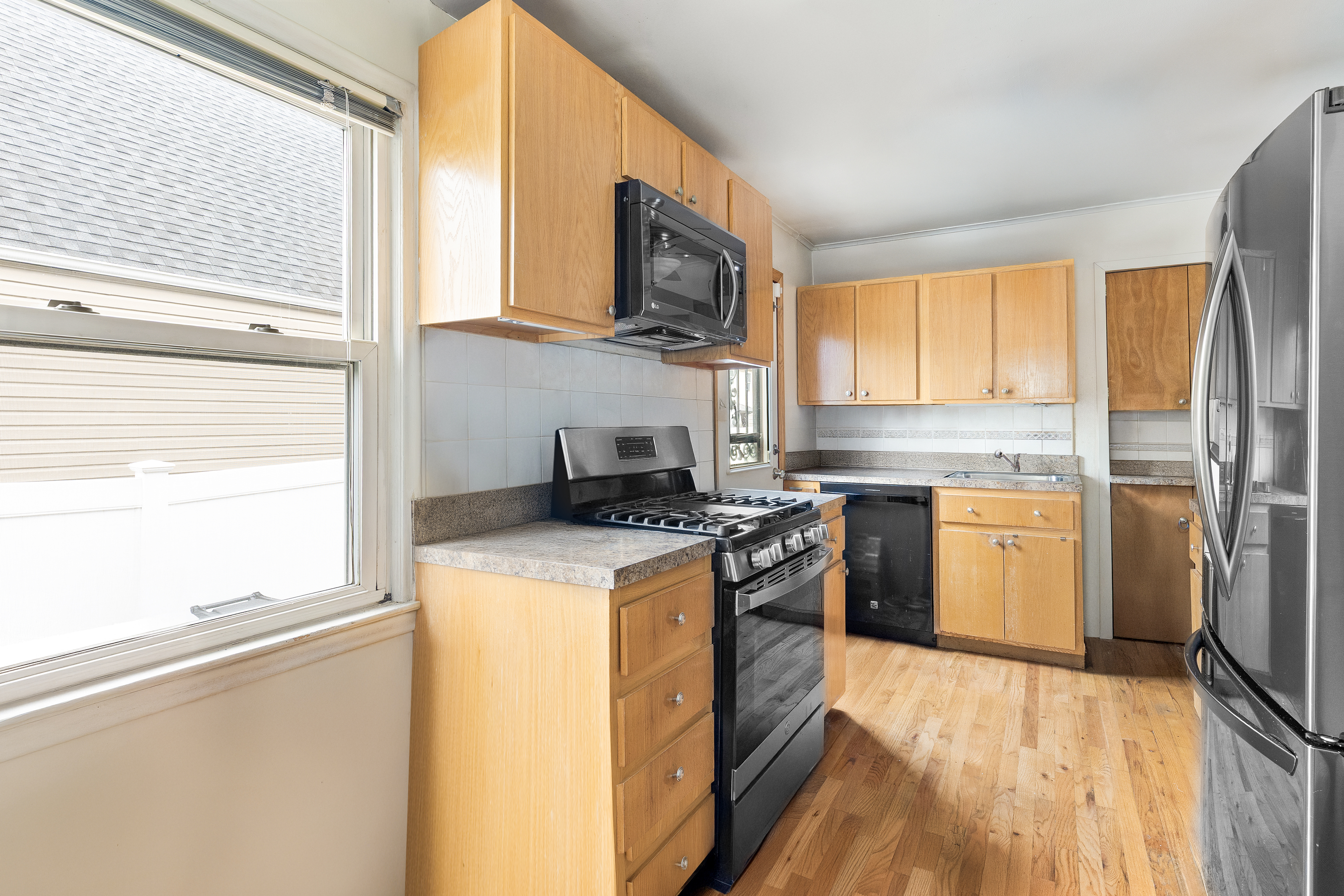 241-12 148th Avenue Queens, NY 11422 - Photo 7 of 15 a kitchen with a stove a sink and a refrigerator