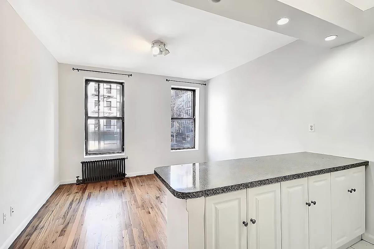 a kitchen with granite countertop a sink a stove and cabinets