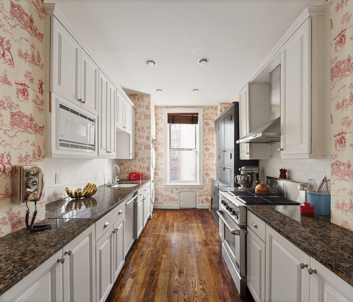 a kitchen with granite countertop a sink a stove refrigerator and cabinets