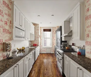 a kitchen with granite countertop a sink a stove refrigerator and cabinets
