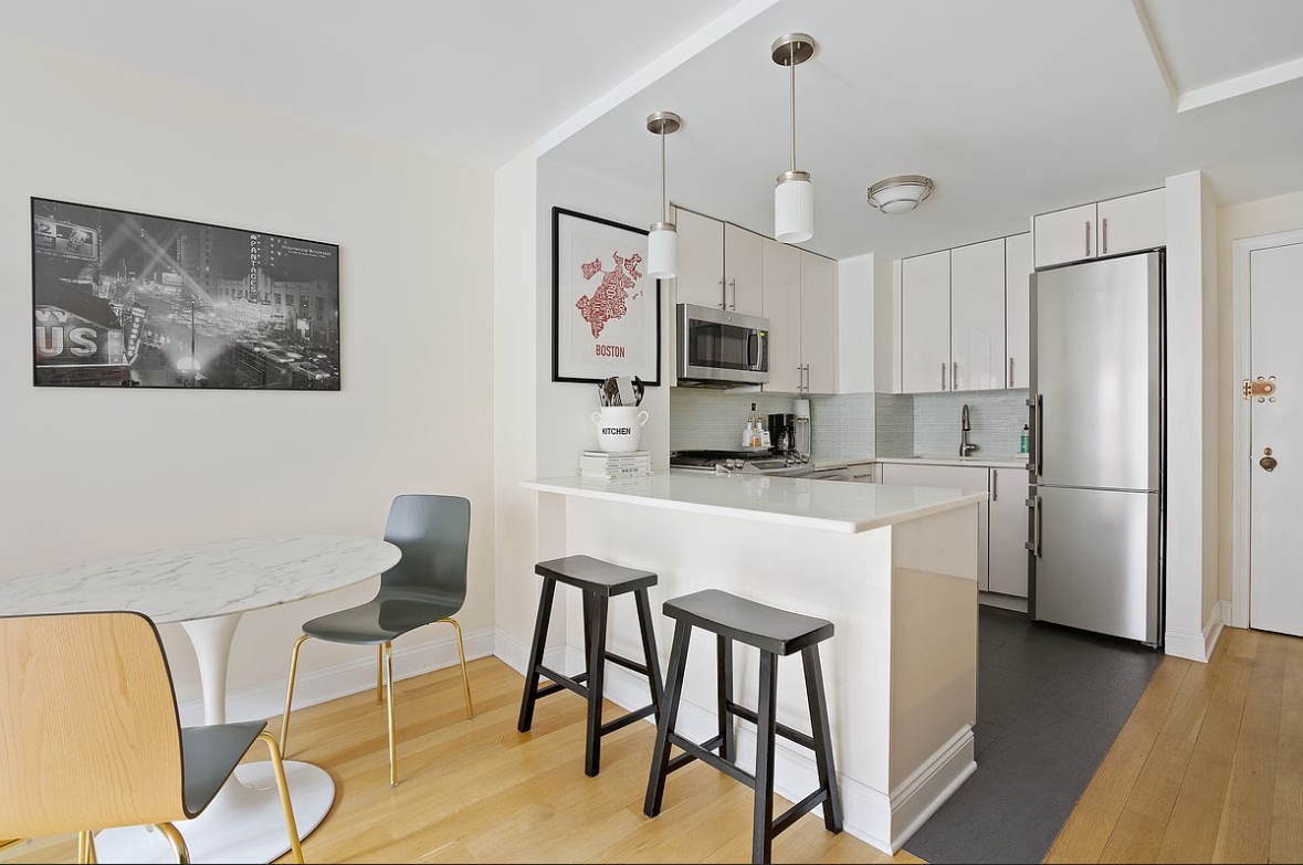 201 East 25th Street, Unit 4C Manhattan, NY 10010 - Photo 2 of 6 a kitchen with kitchen island white cabinets and stainless steel appliances