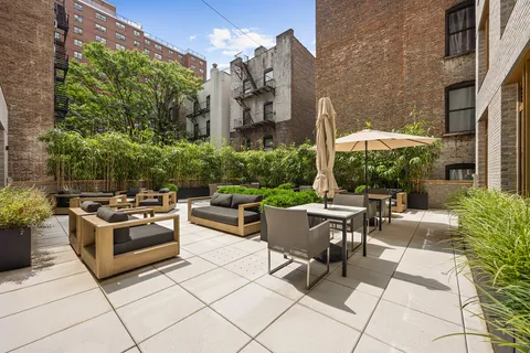 a view of a patio with couches table and chairs and potted plants