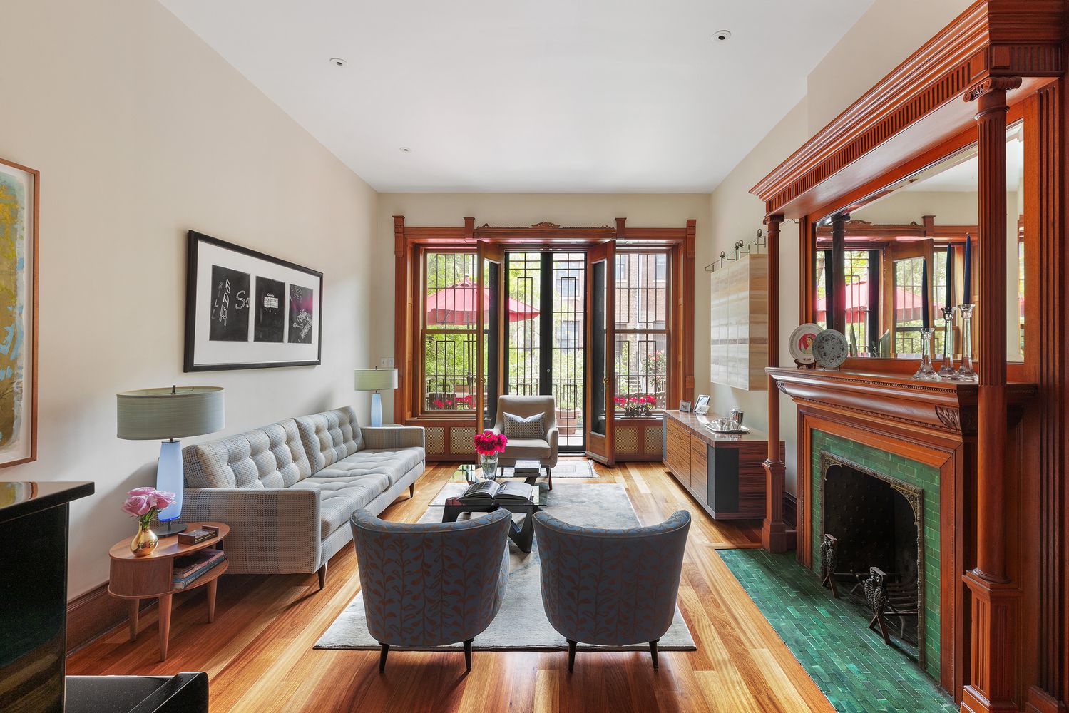 a living room with furniture a fireplace and a floor to ceiling window
