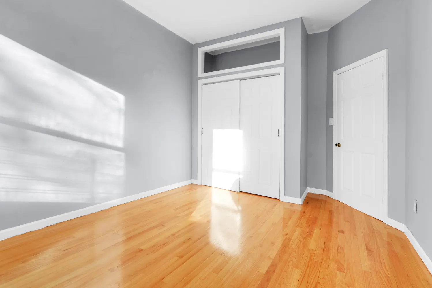 a view of an empty room with wooden floor