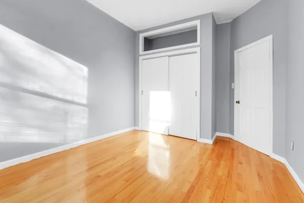 a view of an empty room with wooden floor