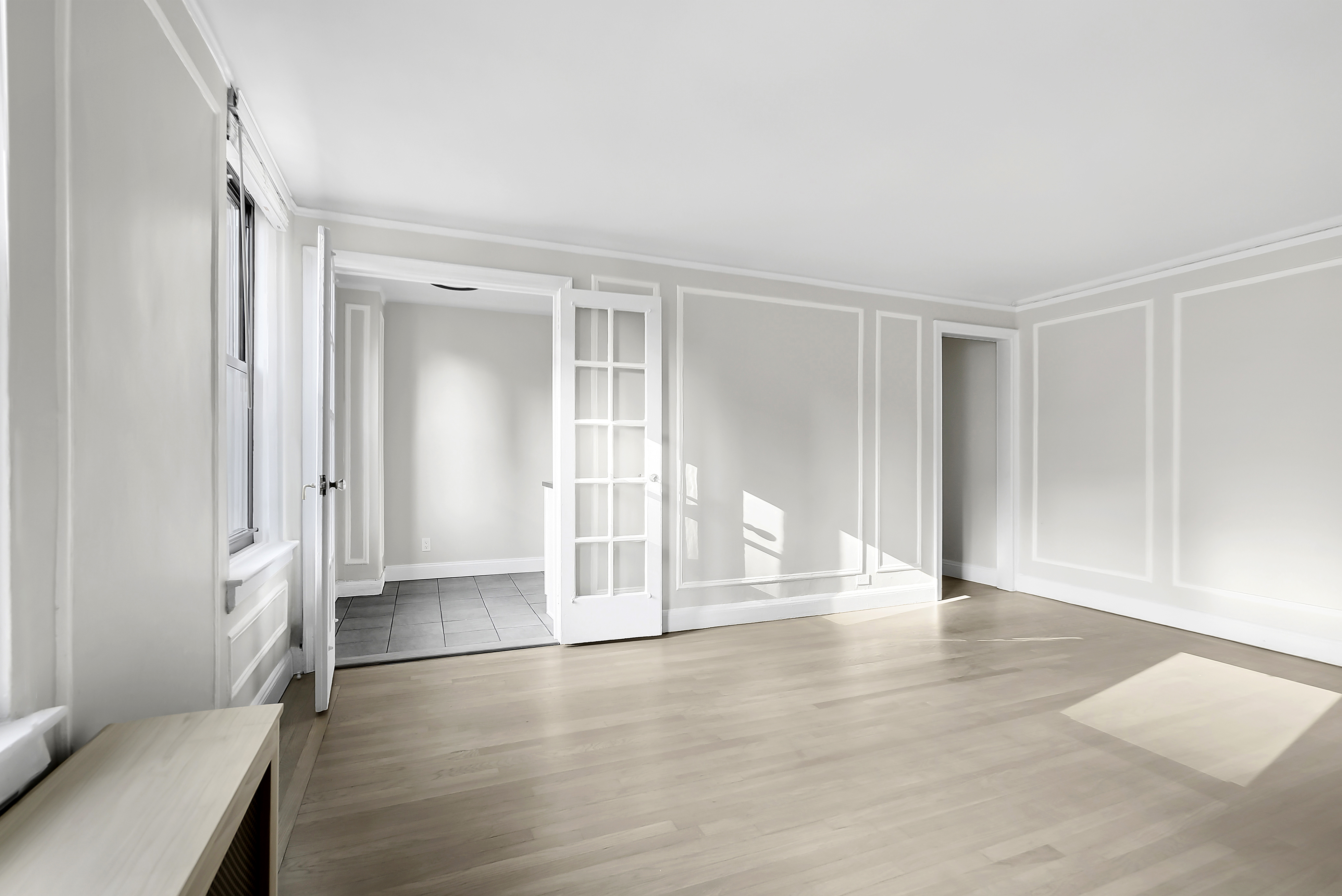 321 East 54th Street, Unit 10B Manhattan, NY 10022 - Photo 2 of 13 a view of an empty room with wooden floor and a window