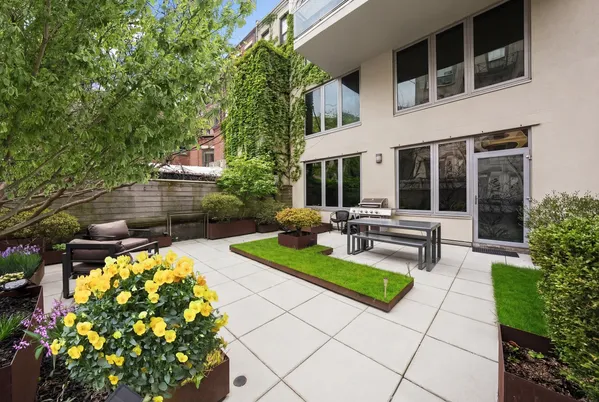 a view of a house with backyard sitting area and garden