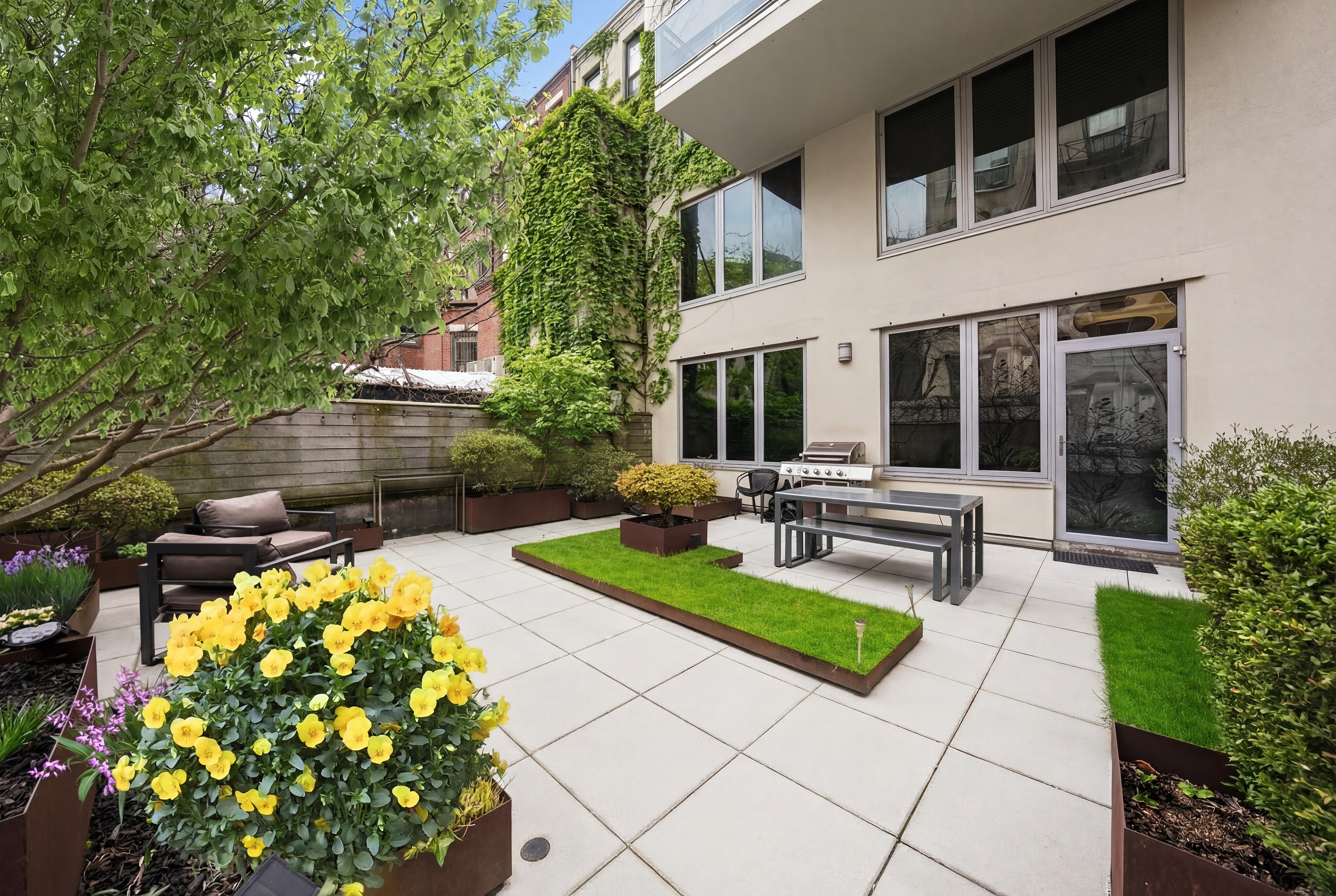 117 West 123rd Street, Unit 1B Manhattan, NY 10027 - Photo 18 of 25 a view of a house with backyard sitting area and garden