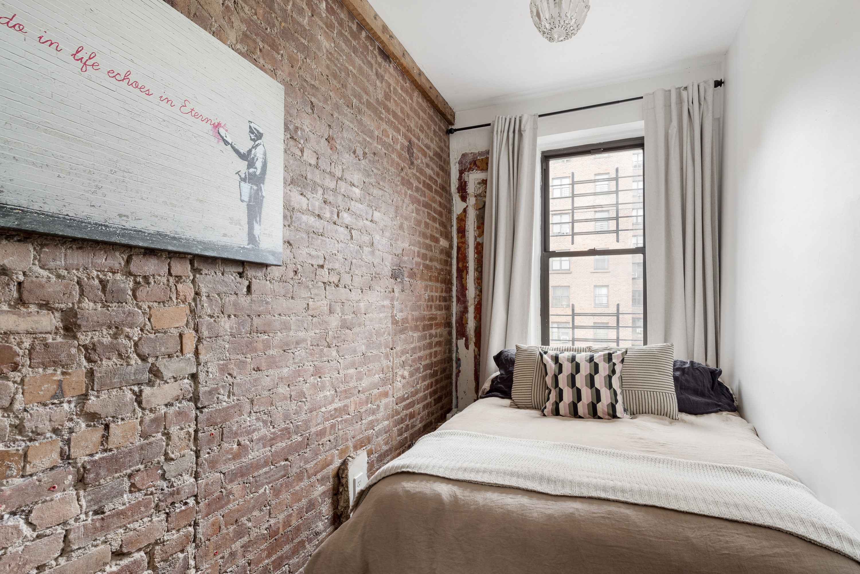 327 East 3rd Street, Unit 4B Manhattan, NY 10009 - Photo 4 of 9 a bedroom with a bed and a window