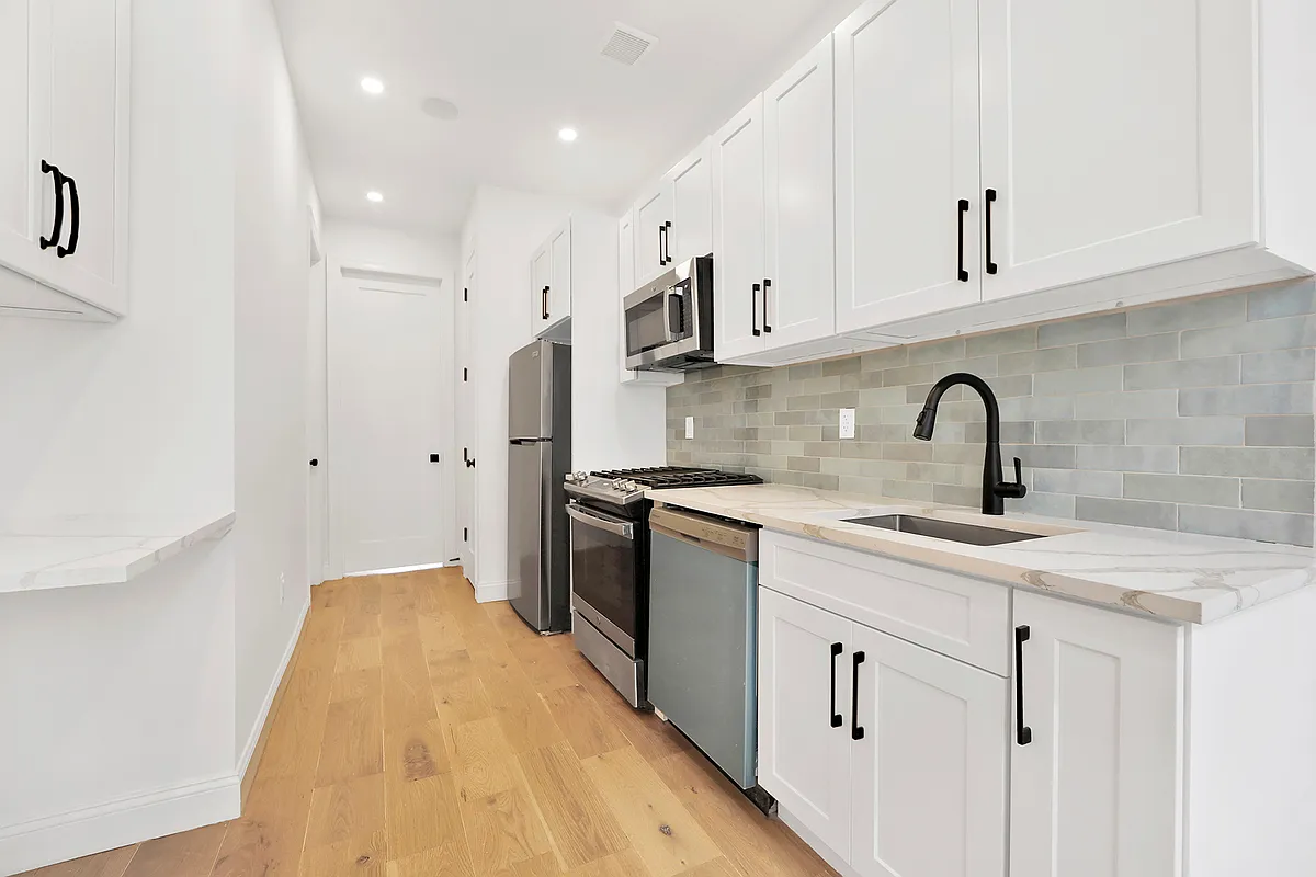 297 Howard Avenue, Unit 2 Brooklyn, NY 11233 - Photo 3 of 13 a kitchen with a sink stove and cabinets