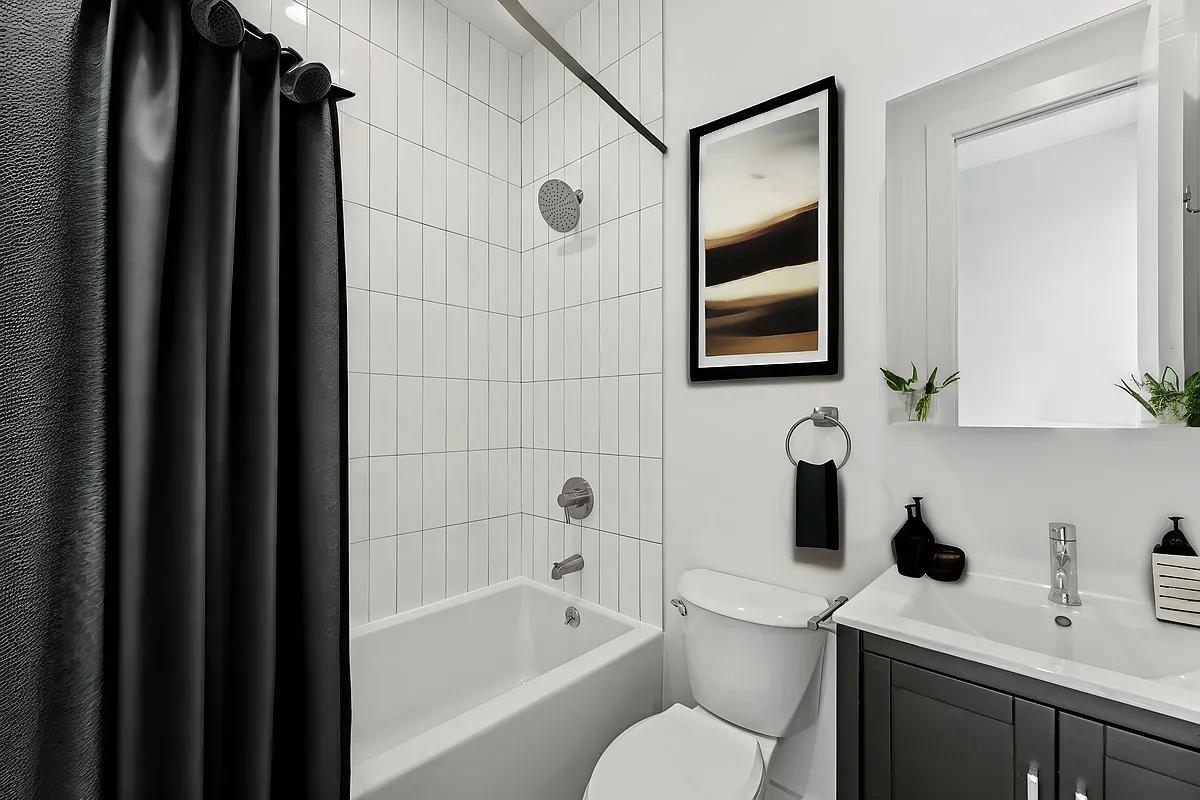 30 Belvidere Street, Unit PH4 Brooklyn, NY 11206 - Photo 7 of 8 a bathroom with a toilet sink vanity tub and mirror