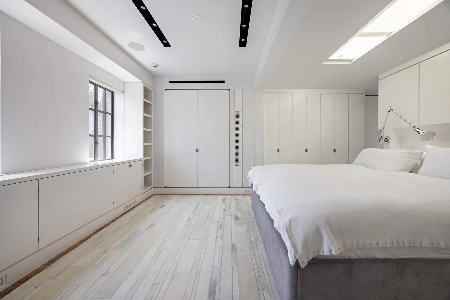 a spacious bedroom with a bed and a window