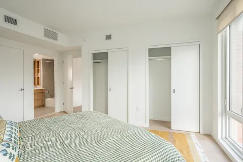 a view of a bedroom with a bed and wooden floor