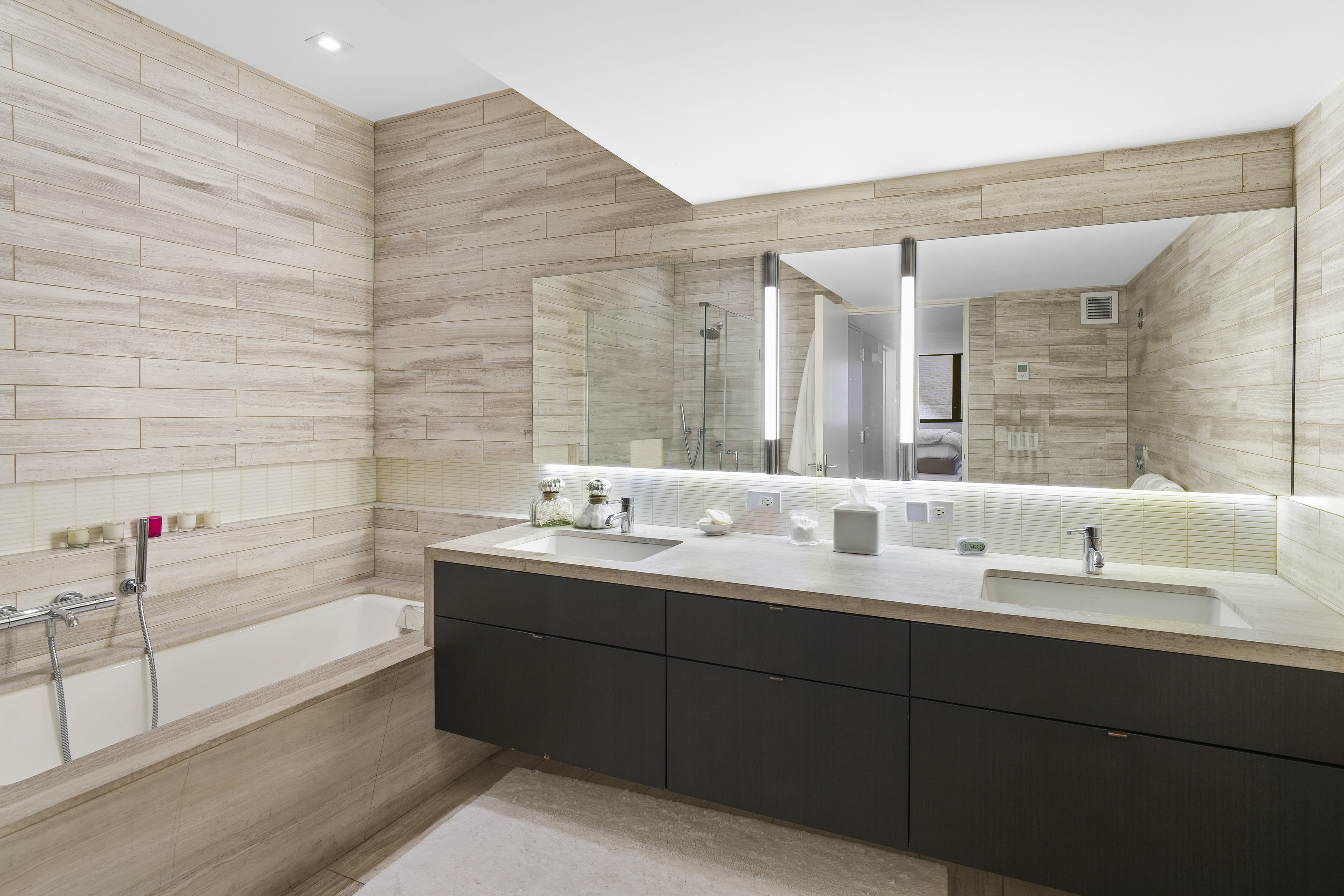 421 Hudson Street, Unit 221 Manhattan, NY 10014 - Photo 6 of 12 a bathroom with a double vanity sink mirror and bathtub