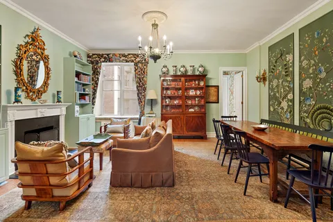 a living room with furniture a chandelier and a fireplace