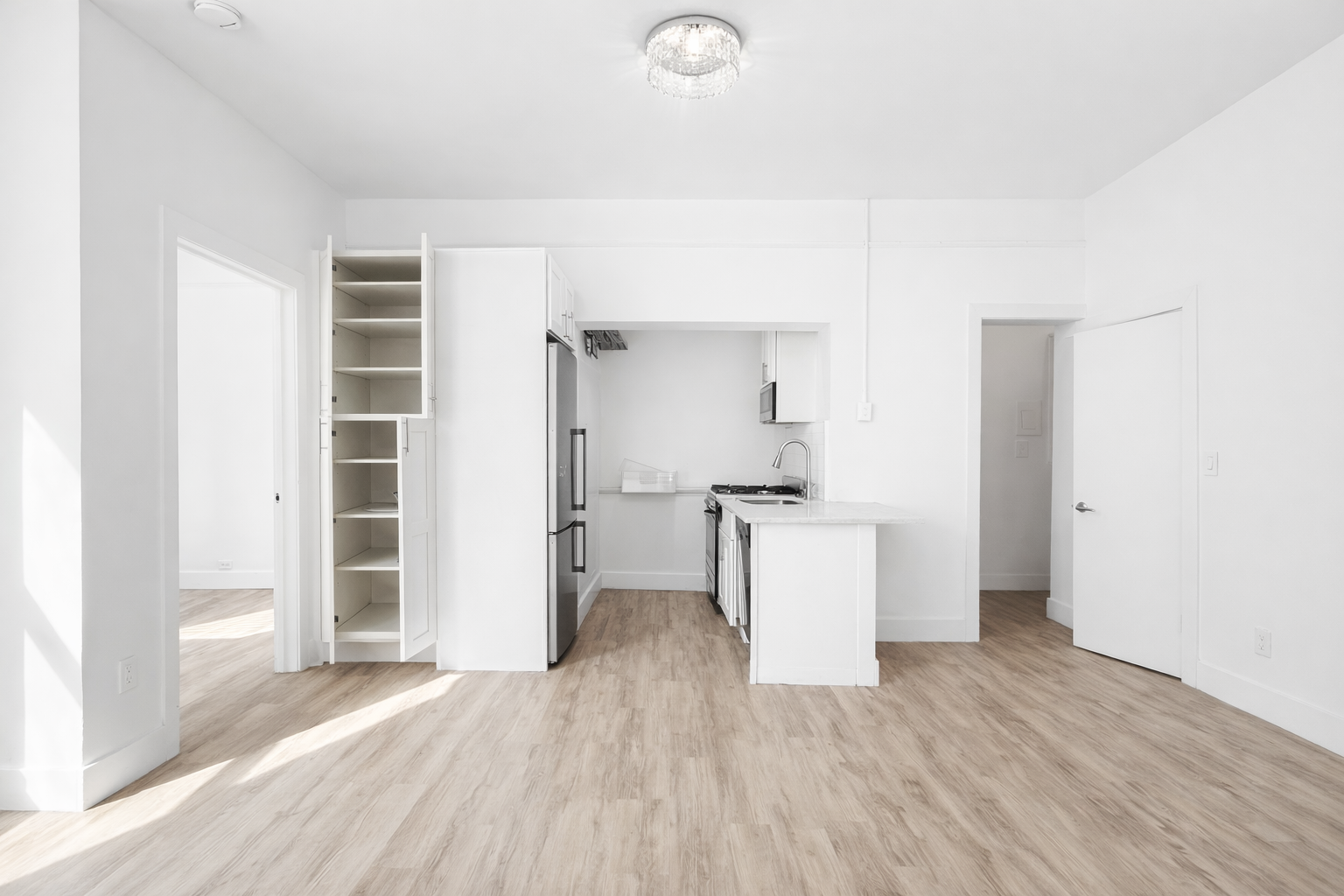 164 West 128th Street, Unit 3C Manhattan, NY 10027 - Photo 3 of 8 a view of a kitchen with wooden floor and a sink
