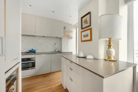a kitchen with a sink cabinets and wooden floor