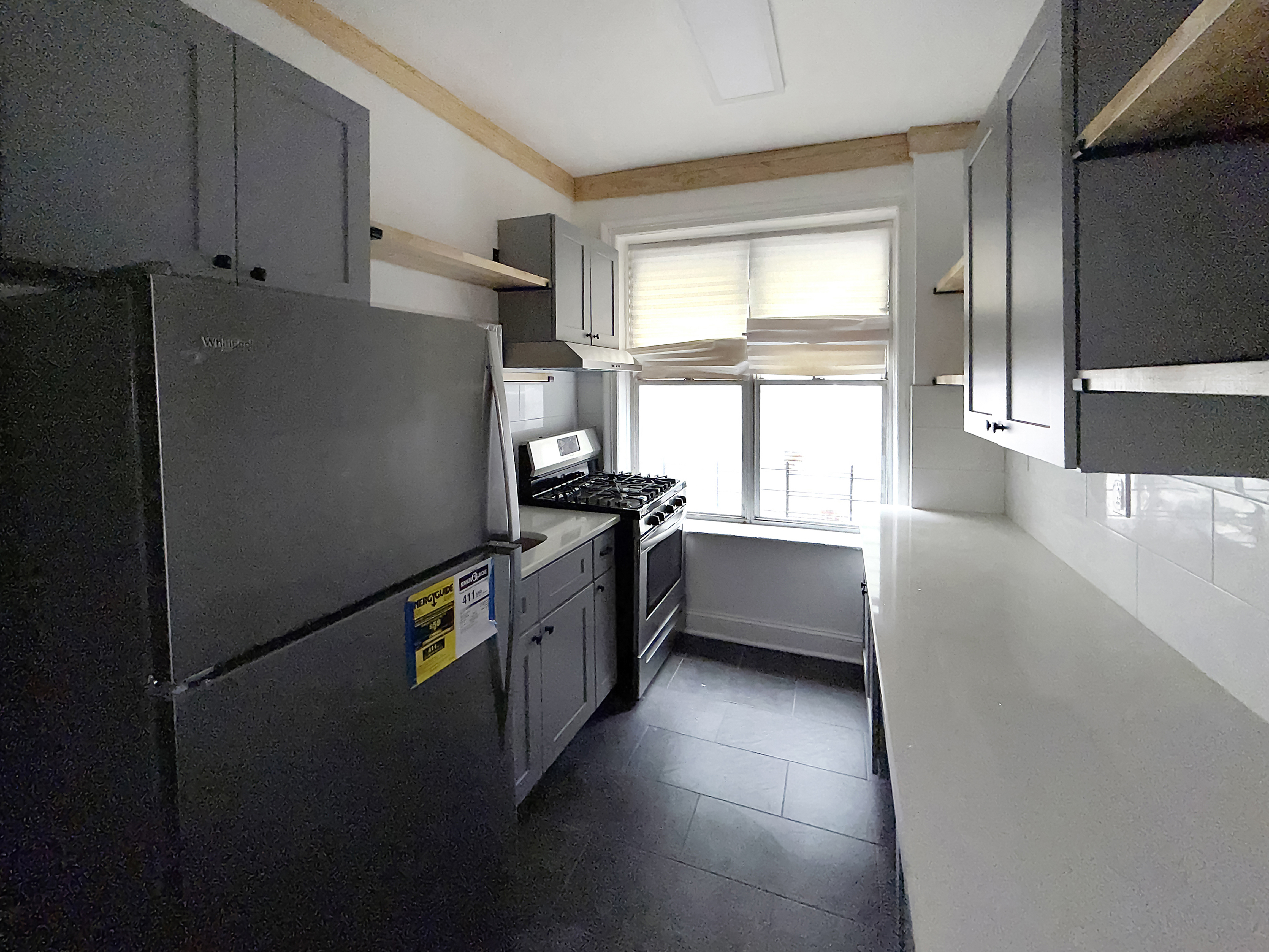 319 East 49th Street, Unit 1 Brooklyn, NY 11203 - Photo 1 of 8 a kitchen with stainless steel appliances a refrigerator sink and cabinets