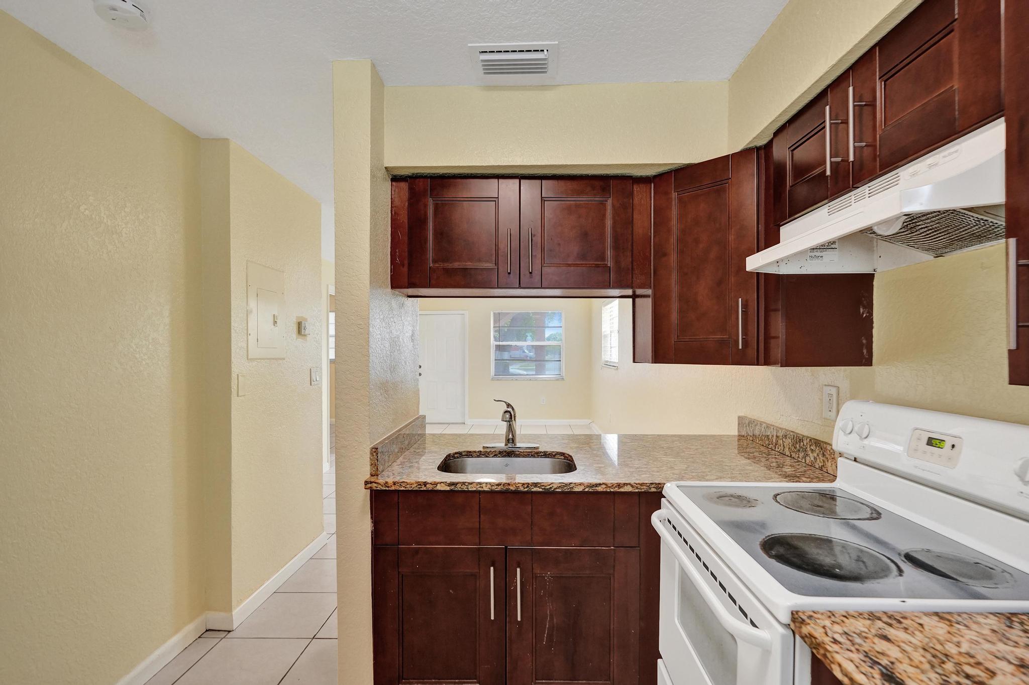 1101 Prospect Road Fort Lauderdale, FL 33309 - Photo 18 of 34 a kitchen with a sink cabinets and a stove top oven