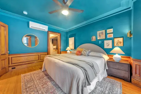 a bedroom with a bed and a dresser next to a window