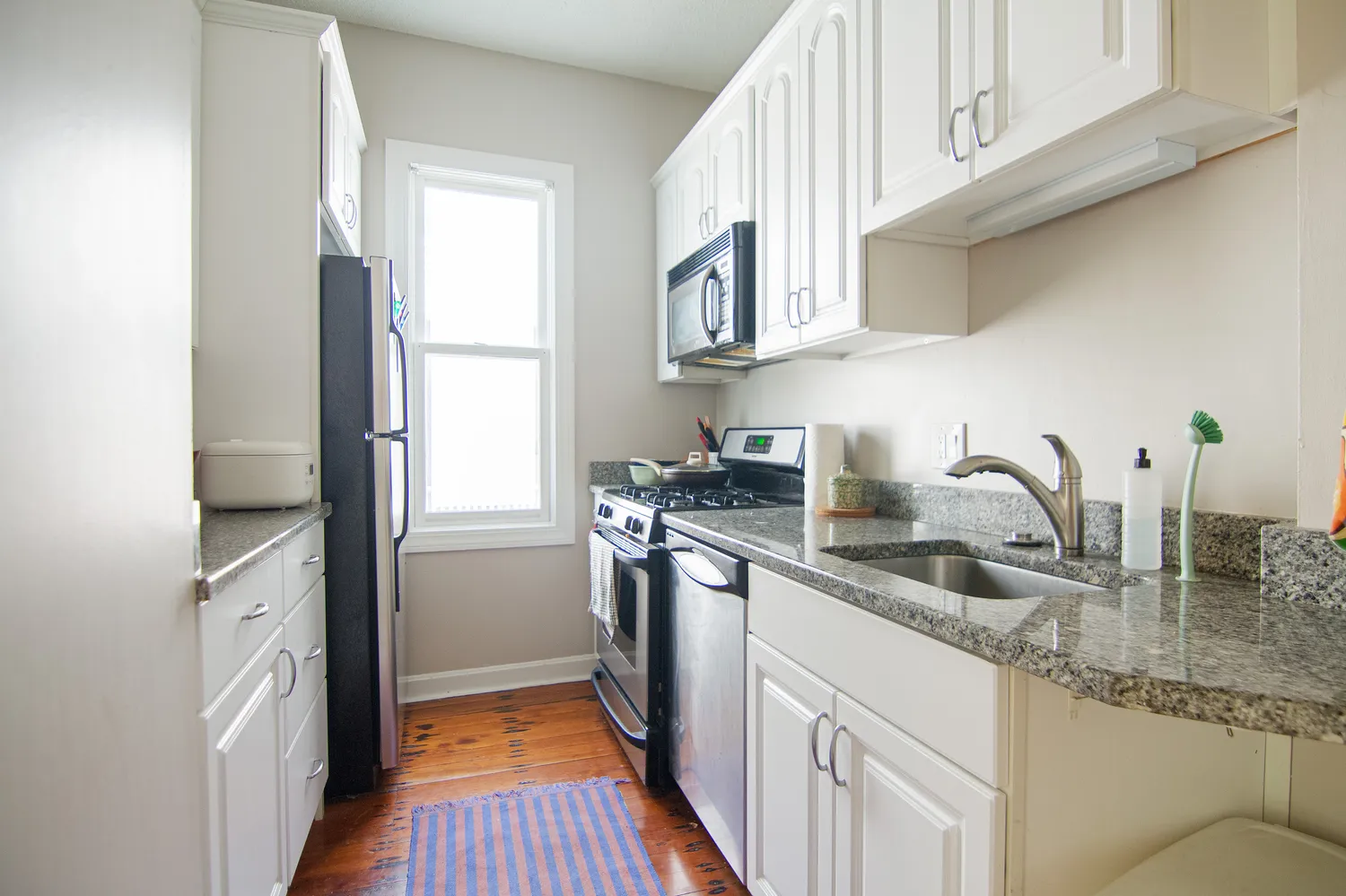 a kitchen with stainless steel appliances granite countertop a sink stove and refrigerator
