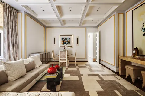 a living room with furniture a rug and white walls